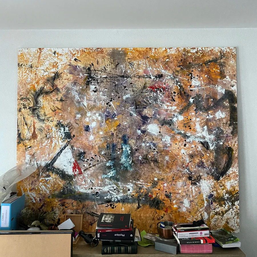Grande toile orange et bleue au-dessus d’une table encombrée