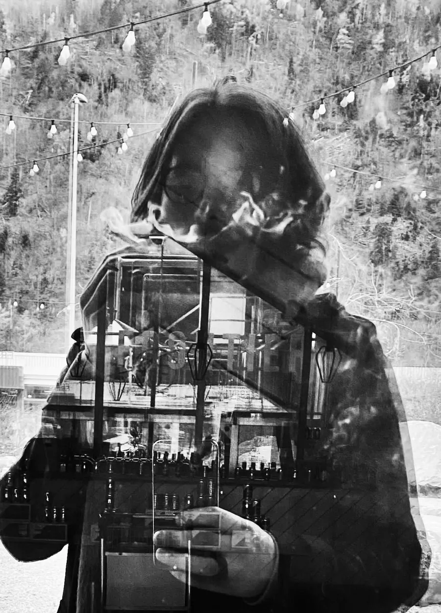 Portrait en noir et blanc dans une vitre, traversé par les reflets d’une fenêtre