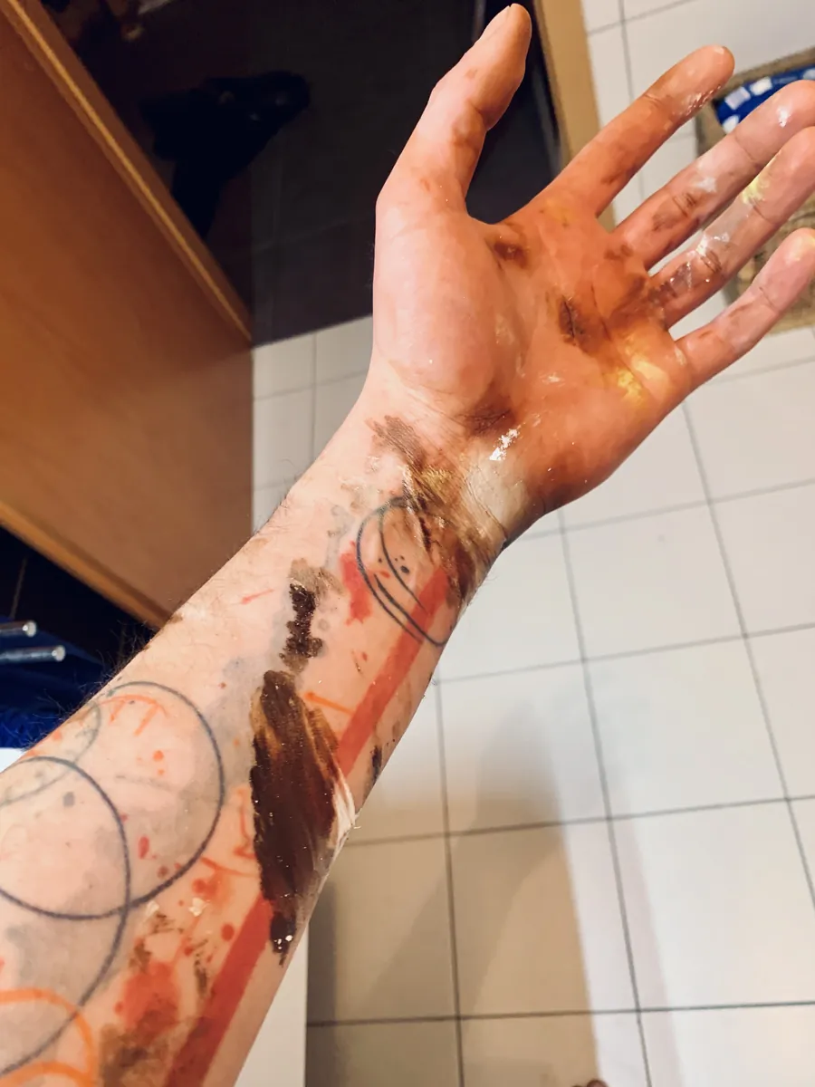 Main ouverte et avant-bras tachés de peinture