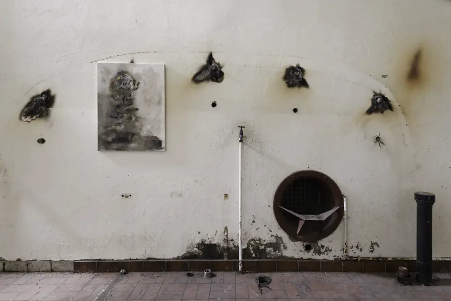 Une peinture suspendue au mur blanc des anciennes caves Provins