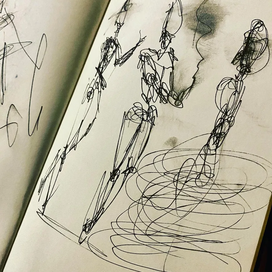 Un carnet ouvert rempli de silhouettes à l’encre