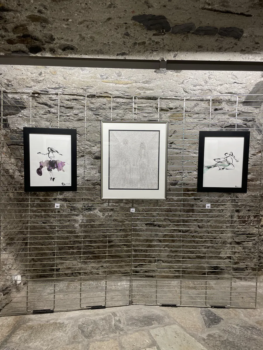 Dessins accrochés à un mur de pierre