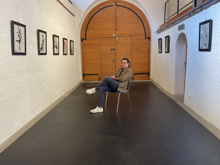 Une personne assise parmi les dessins exposés